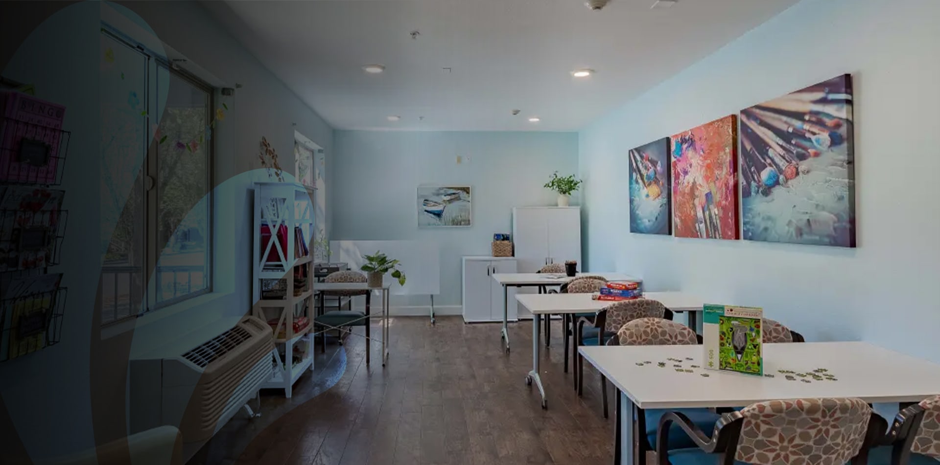 Bright activity room with tables and artwork.