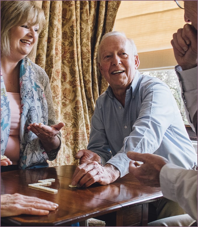 Residents enjoying a game in a cozy common area.