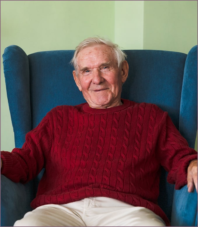 Smiling elderly man in a cozy chair