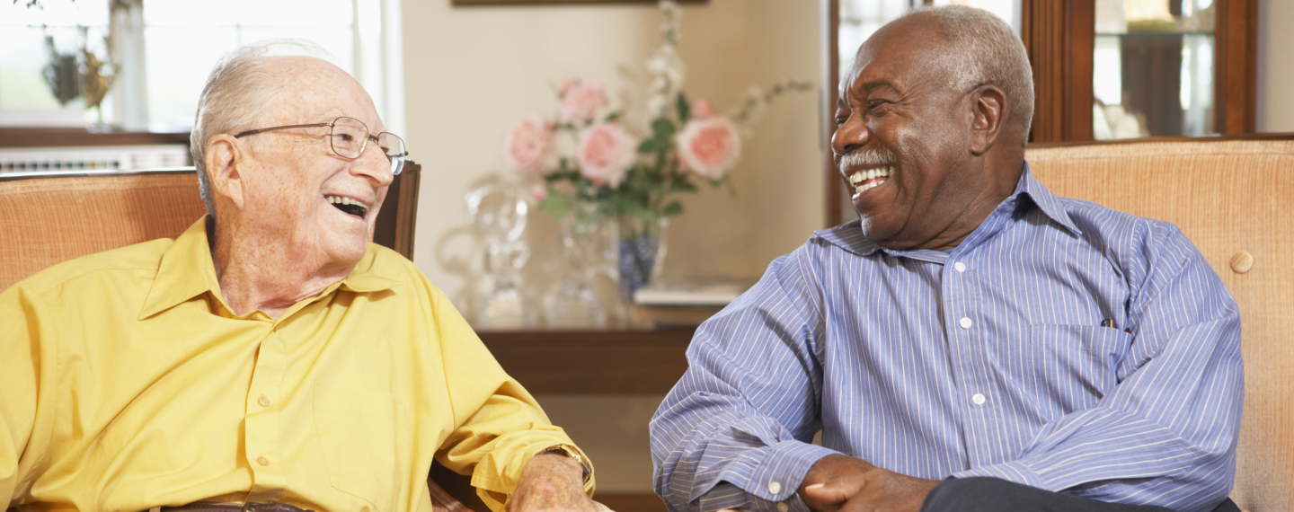 Two elderly men enjoying a laugh together.