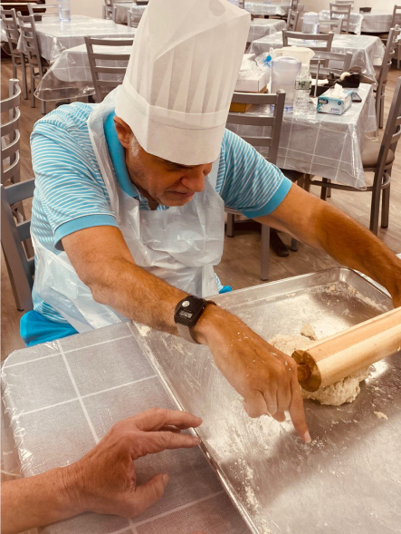 Senior man baking with a rolling pin in a kitchen