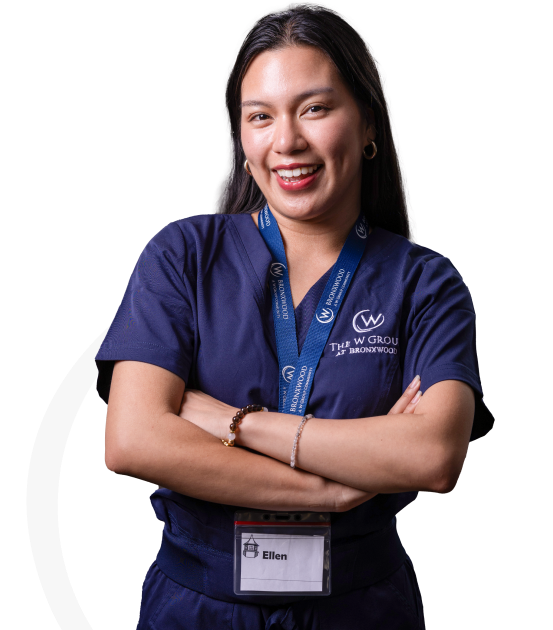 Staff member smiling with arms crossed