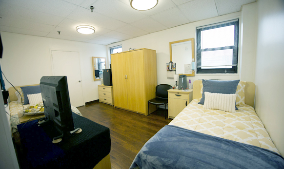 Cozy resident room with two beds and a TV.
