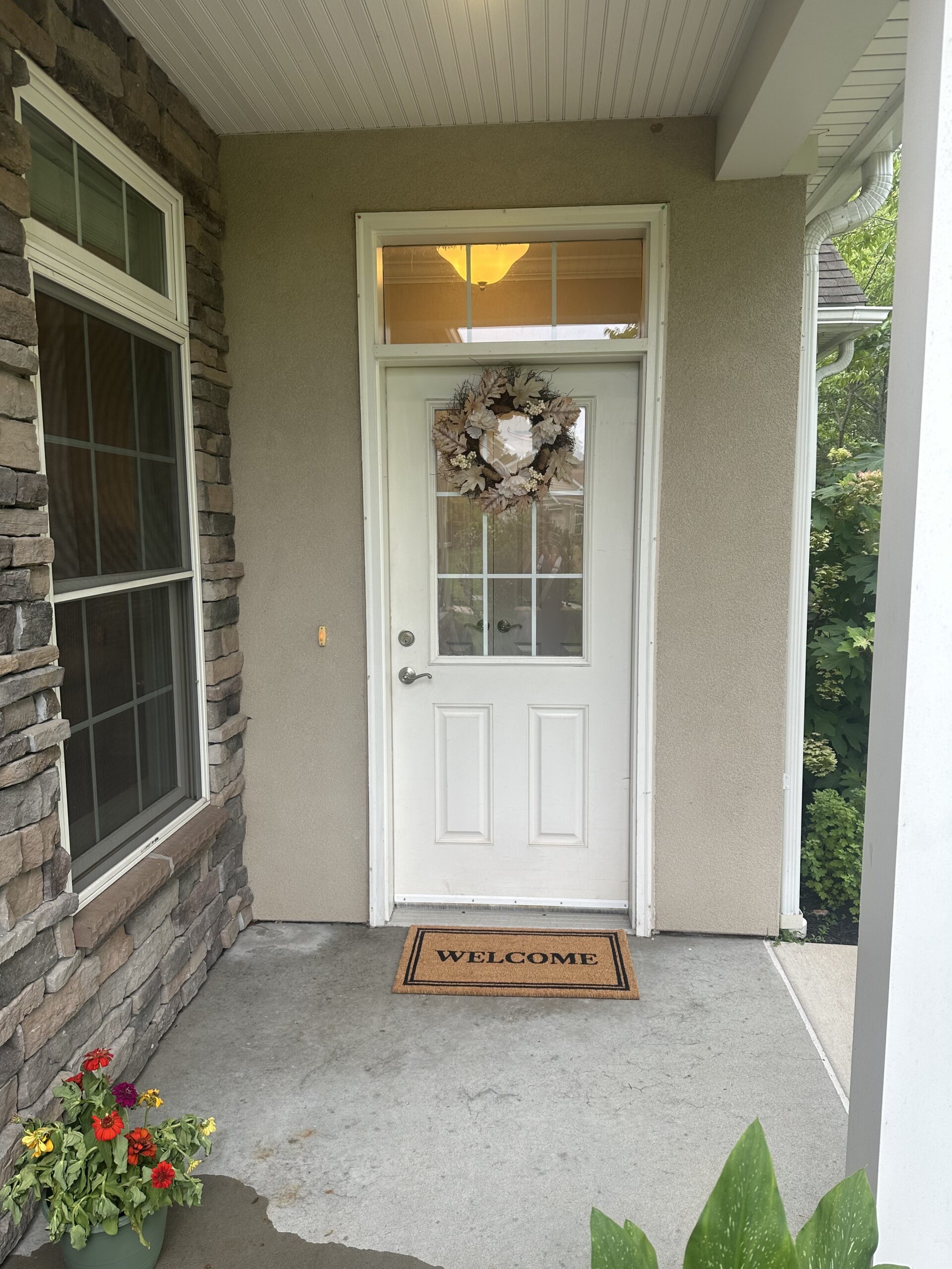 Entrance of a facility with a welcome mat and flowers
