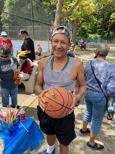 Senior man holding a basketball outdoors, community activity