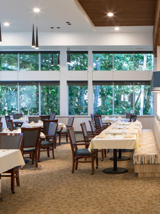 Bright dining area with large windows and tables set for meals