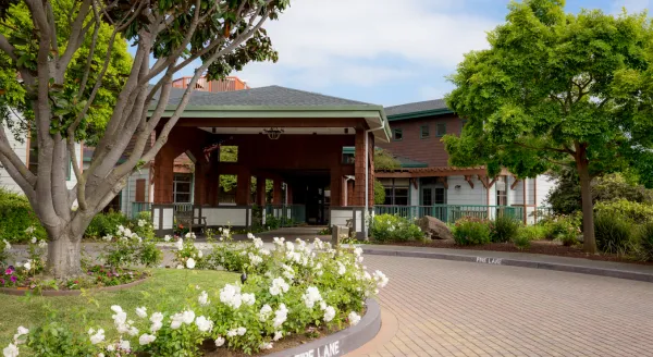 Exterior view of a senior living facility entrance with flowers