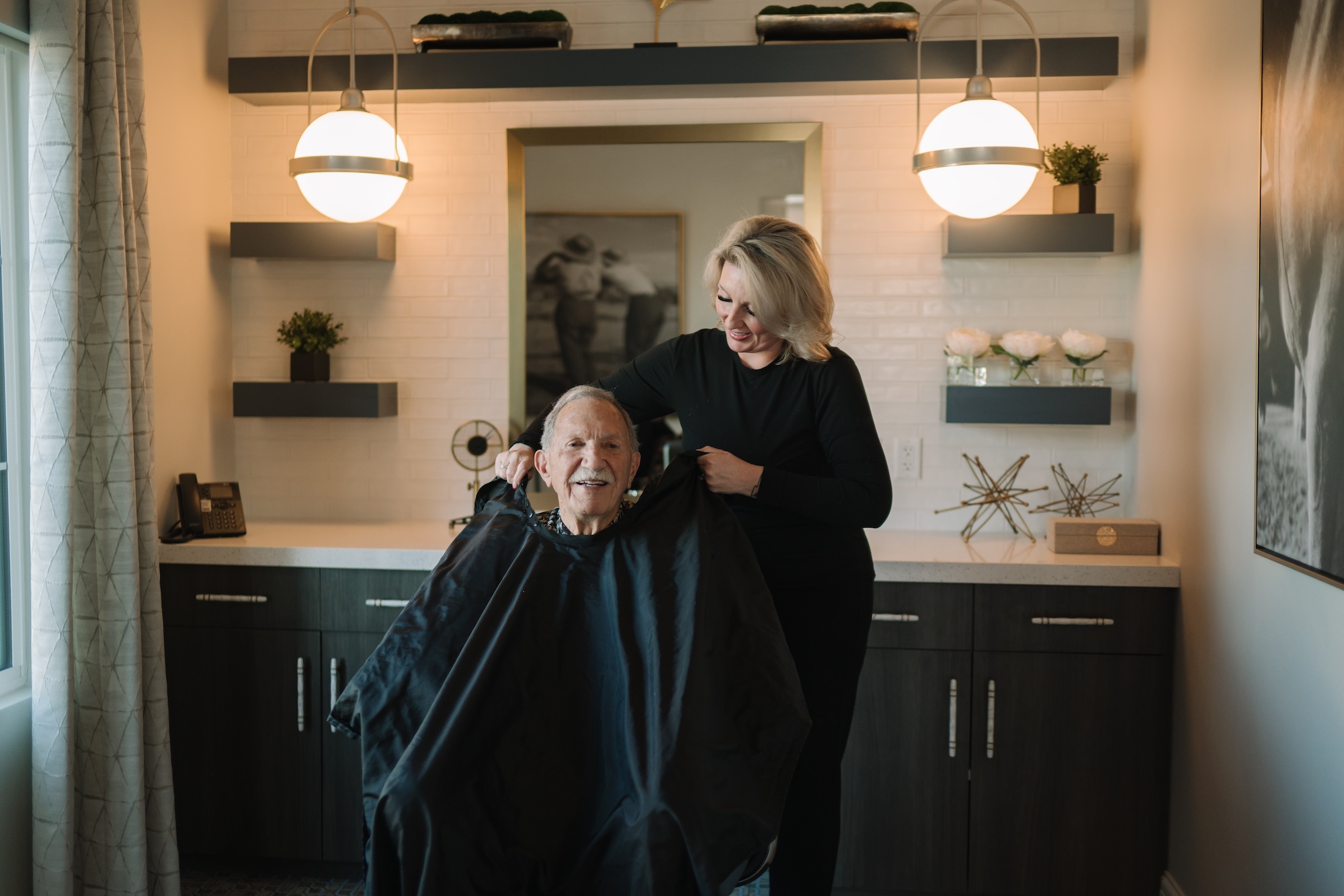Hair salon scene with a smiling resident and stylist