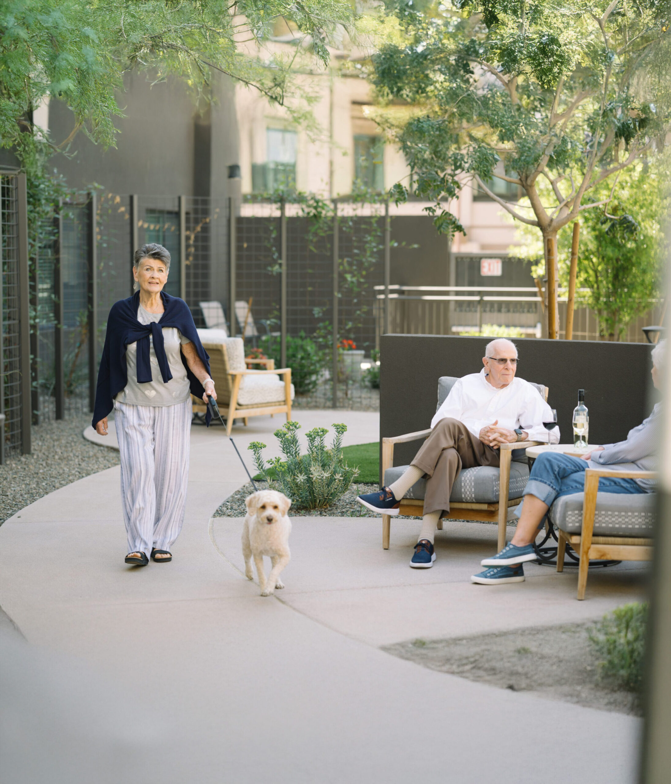 Residents enjoying a walk in the outdoor space with a dog