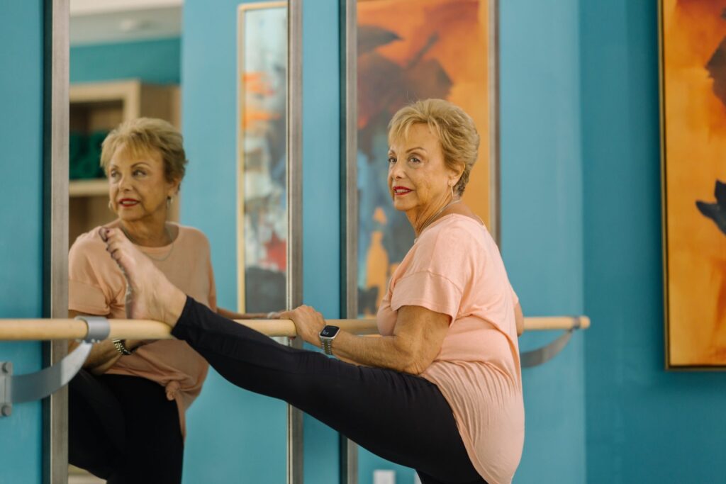 Senior woman participating in a ballet stretching activity