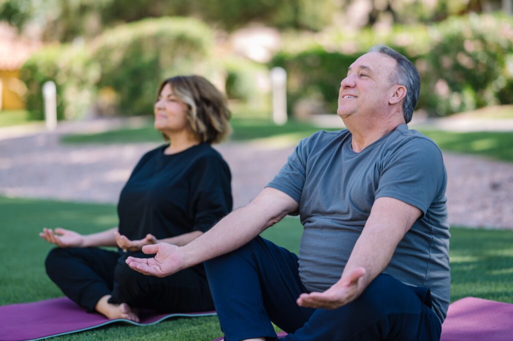 Two residents practicing yoga outdoors
