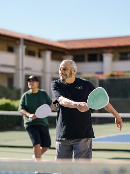 Elderly men playing tennis outdoors
