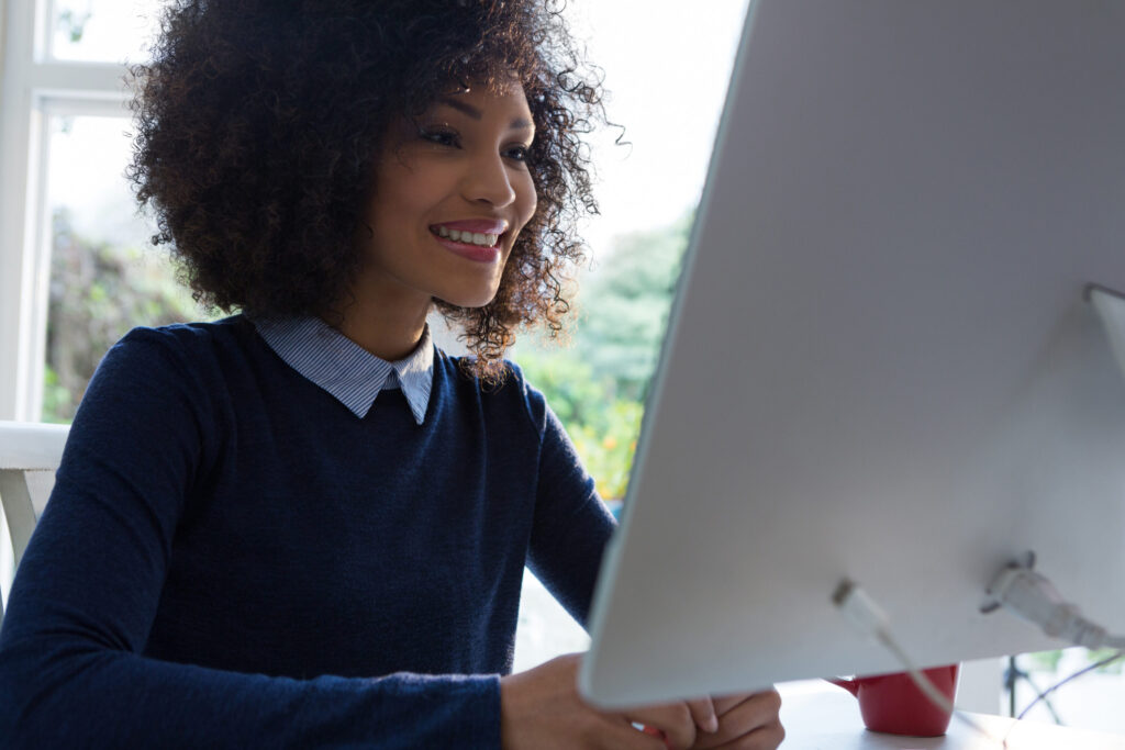 Woman smiling while working on a computer