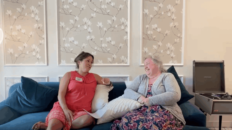 Resident and staff member chatting in a cozy lounge area