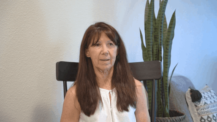 A woman sitting in a chair in an interior space