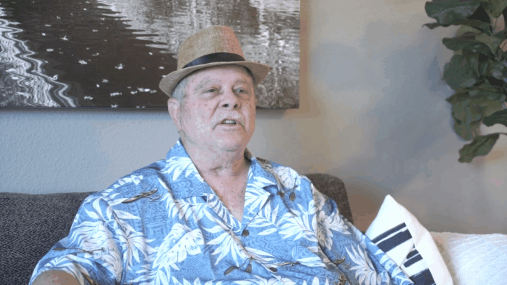 A resident sitting on a couch wearing a straw hat
