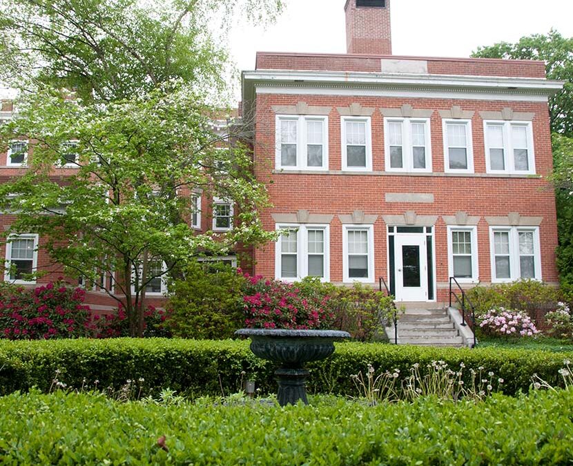 Brick building exterior with landscaping and fountain