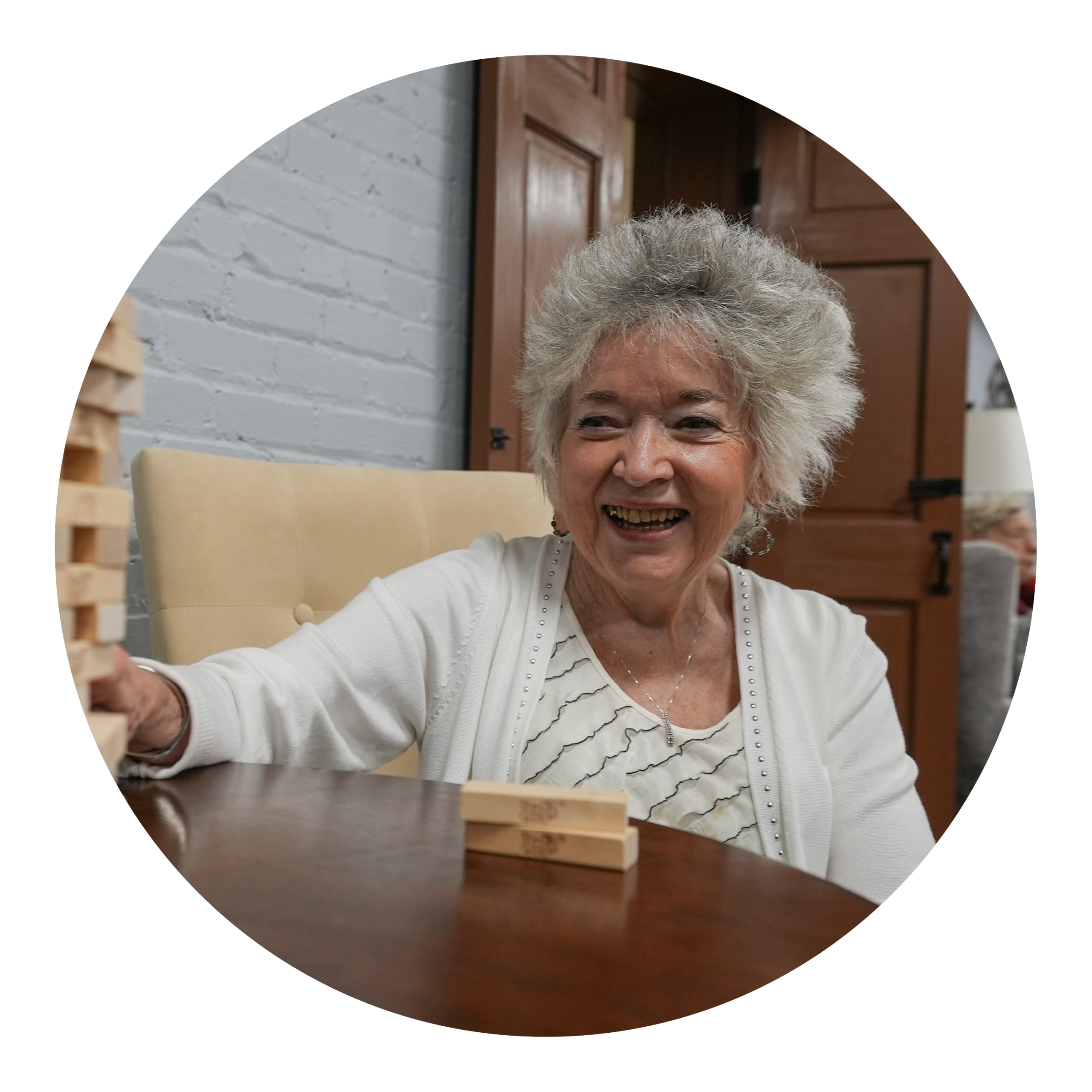 Resident enjoying a game of Jenga in a cozy interior setting