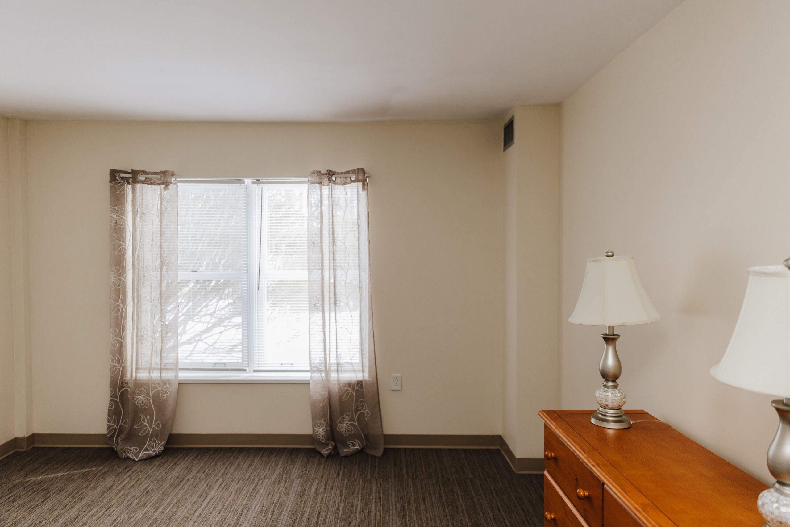 A cozy resident room with window and furniture
