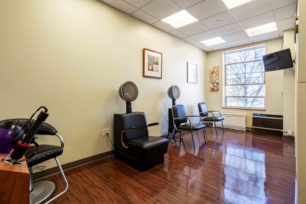Interior salon area with styling chairs and a window