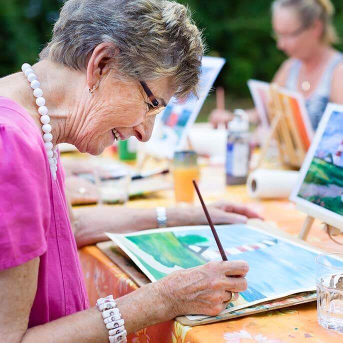 Residents painting during an outdoor art activity