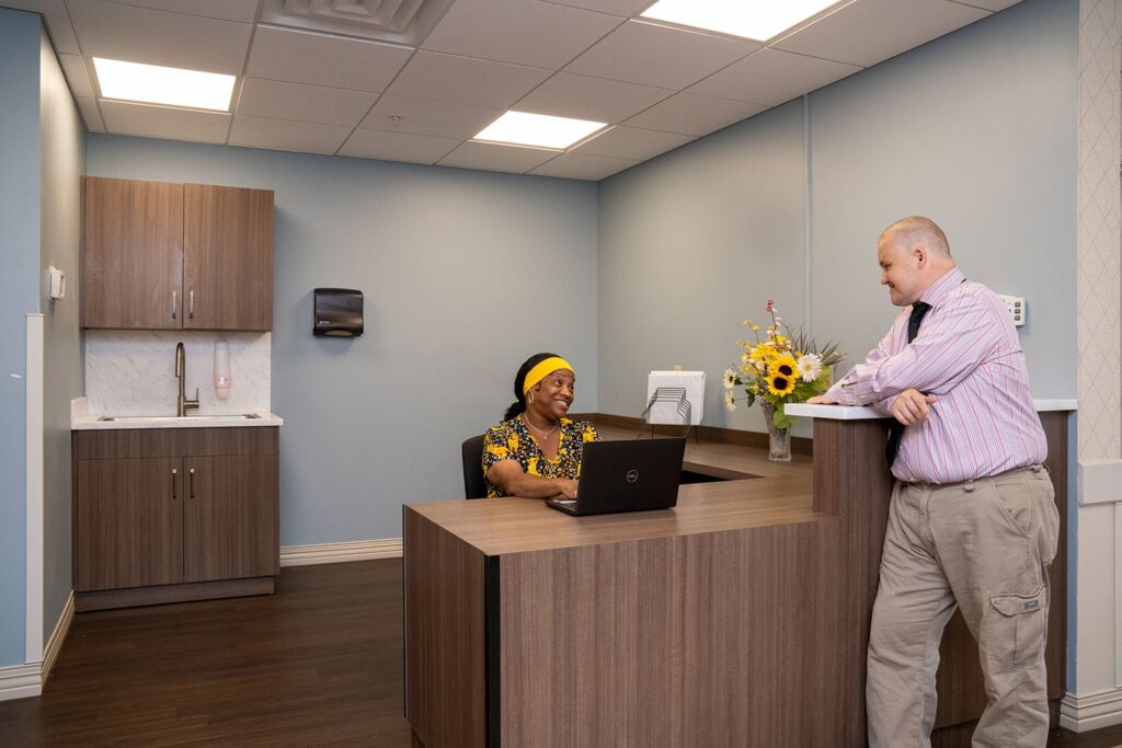 Staff member assisting a resident at the reception desk