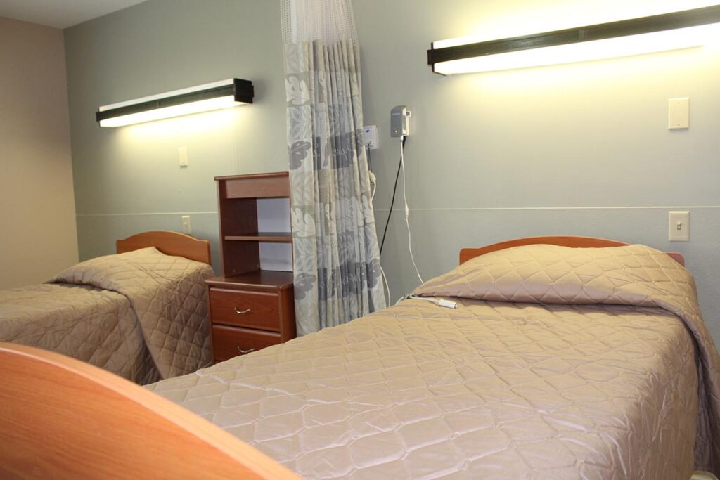 A twin-bedded resident room with warm lighting