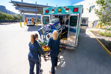 Emergency medical team loading a stretcher into an ambulance