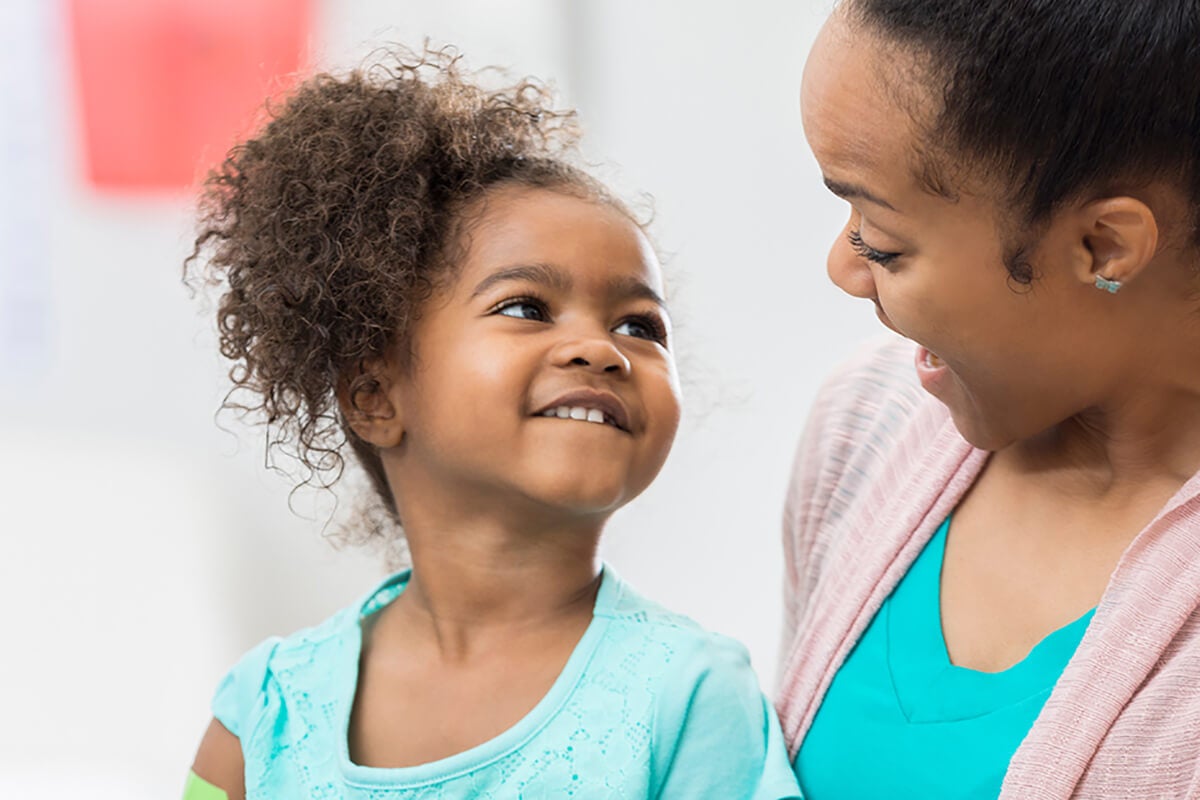 A woman and child smiling at each other