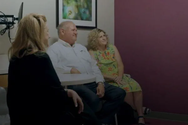 Residents and staff engaged in conversation in an interior space