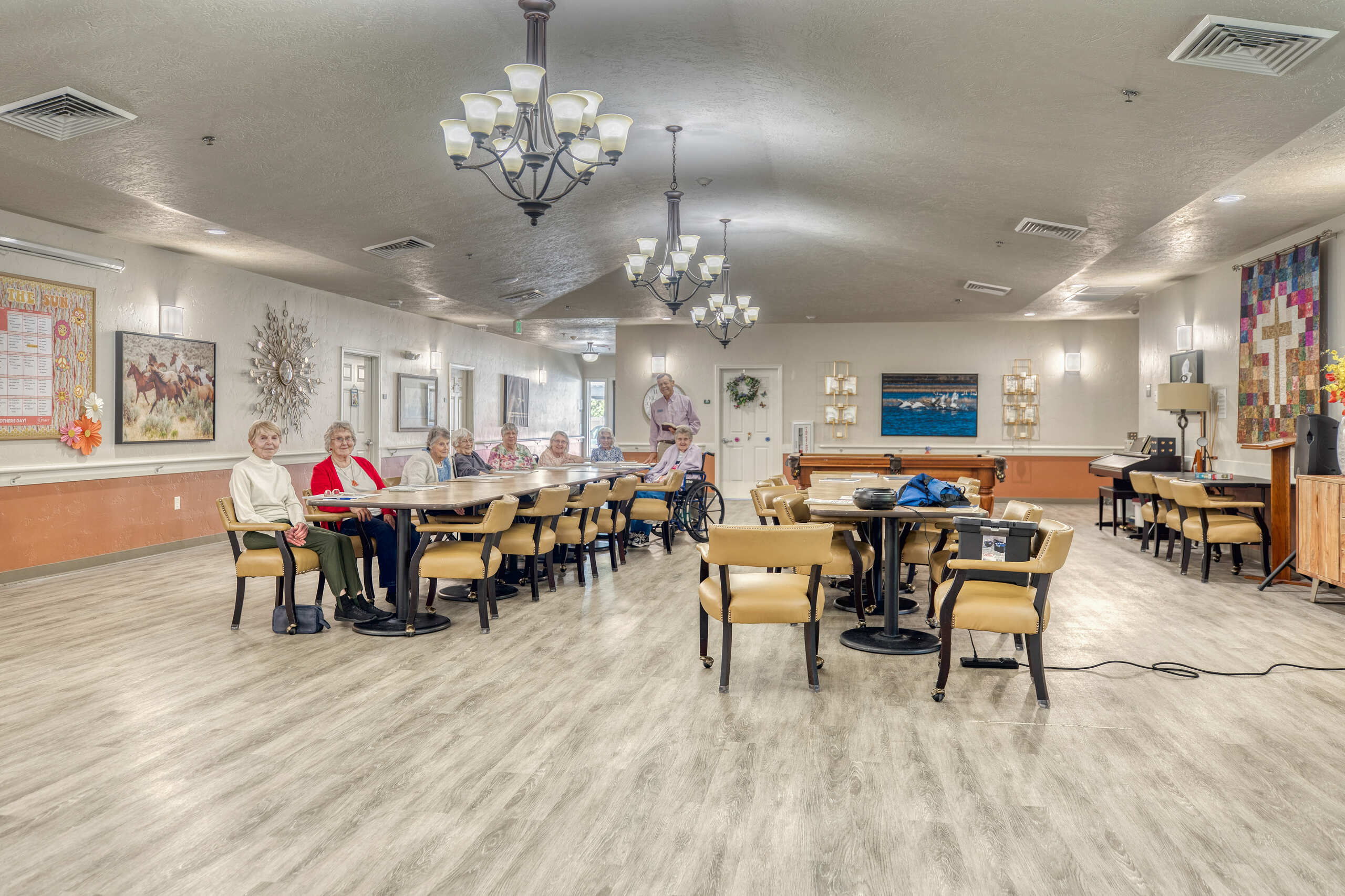Residents socializing in a common area with tables and chairs