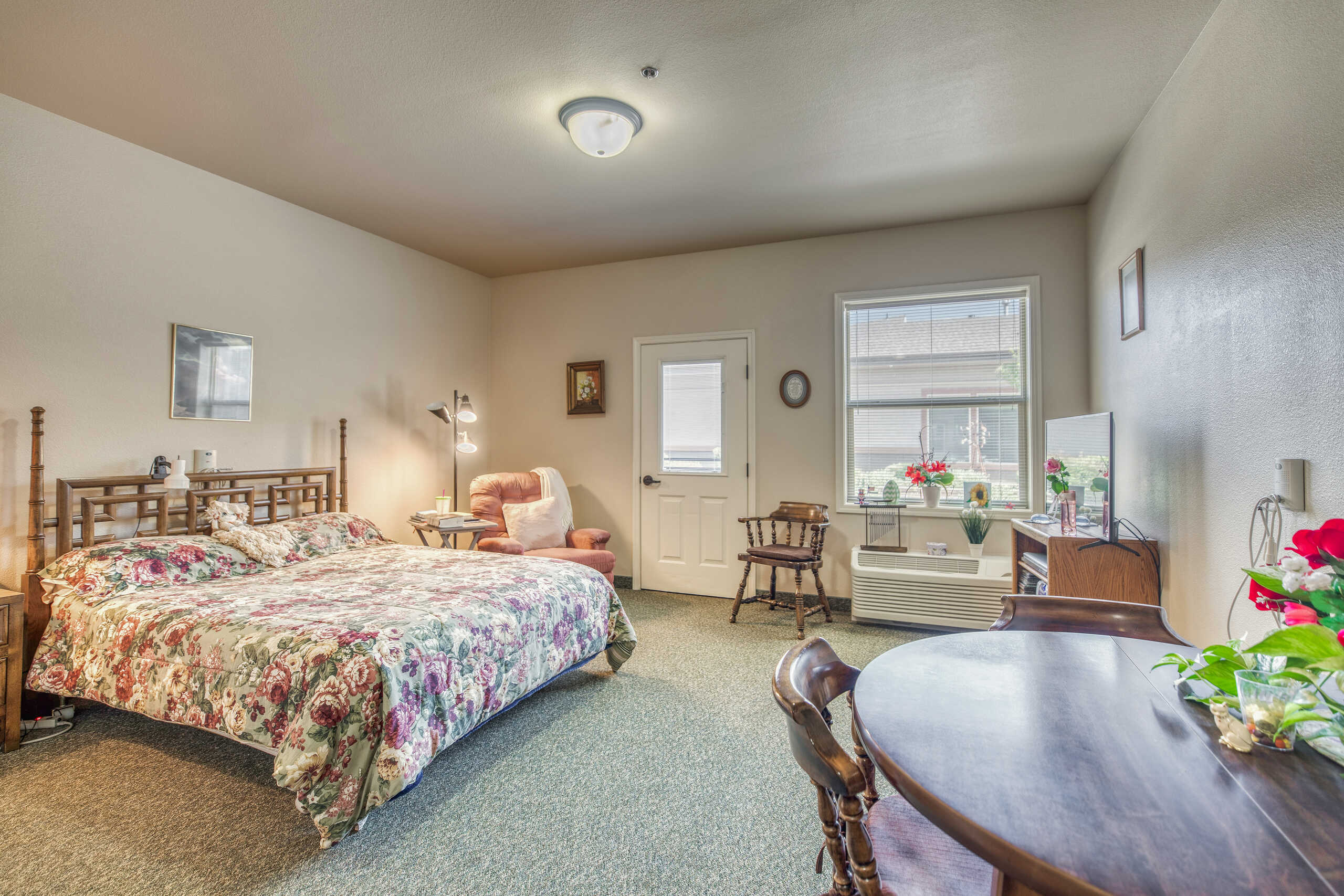Cozy resident room with floral bedding and furniture