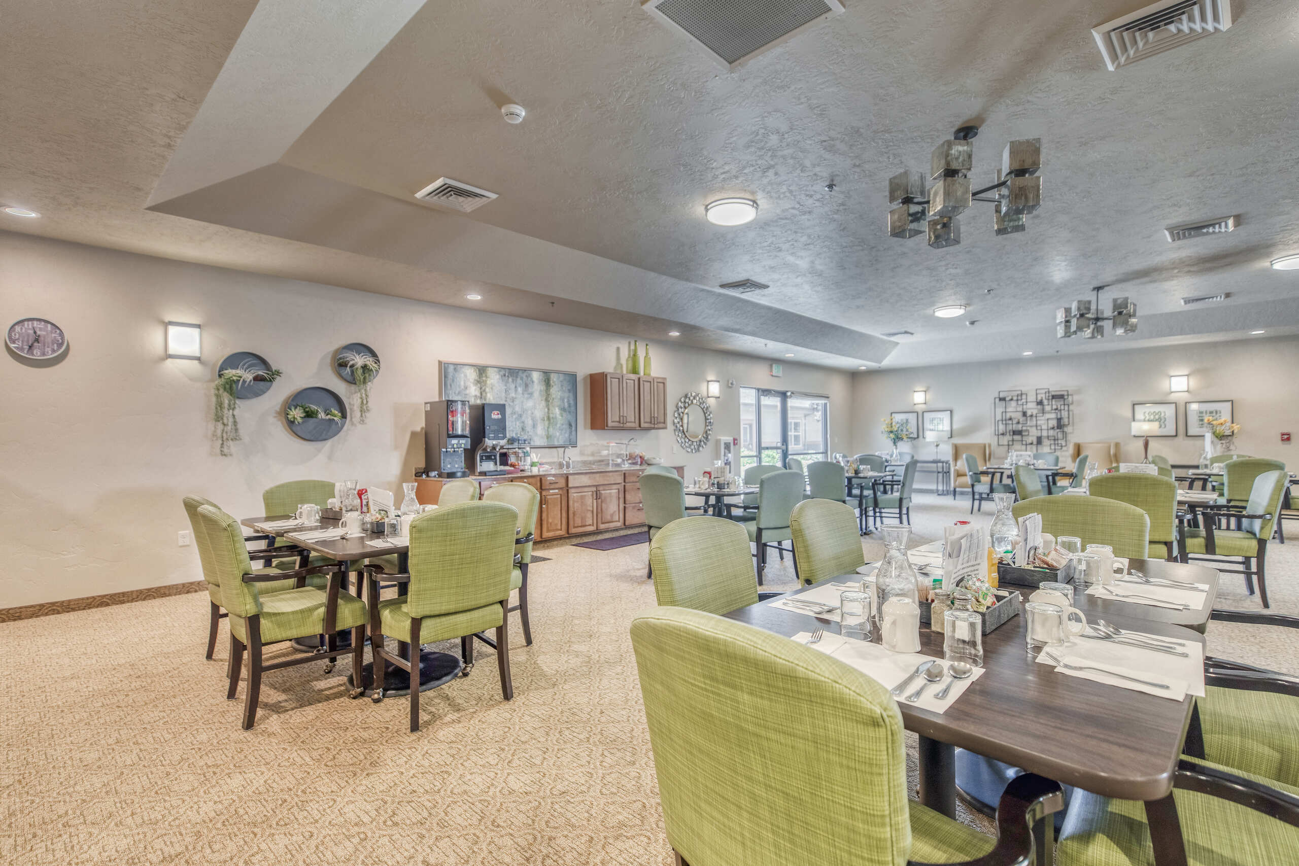 Dining area with green chairs and tables set for meals