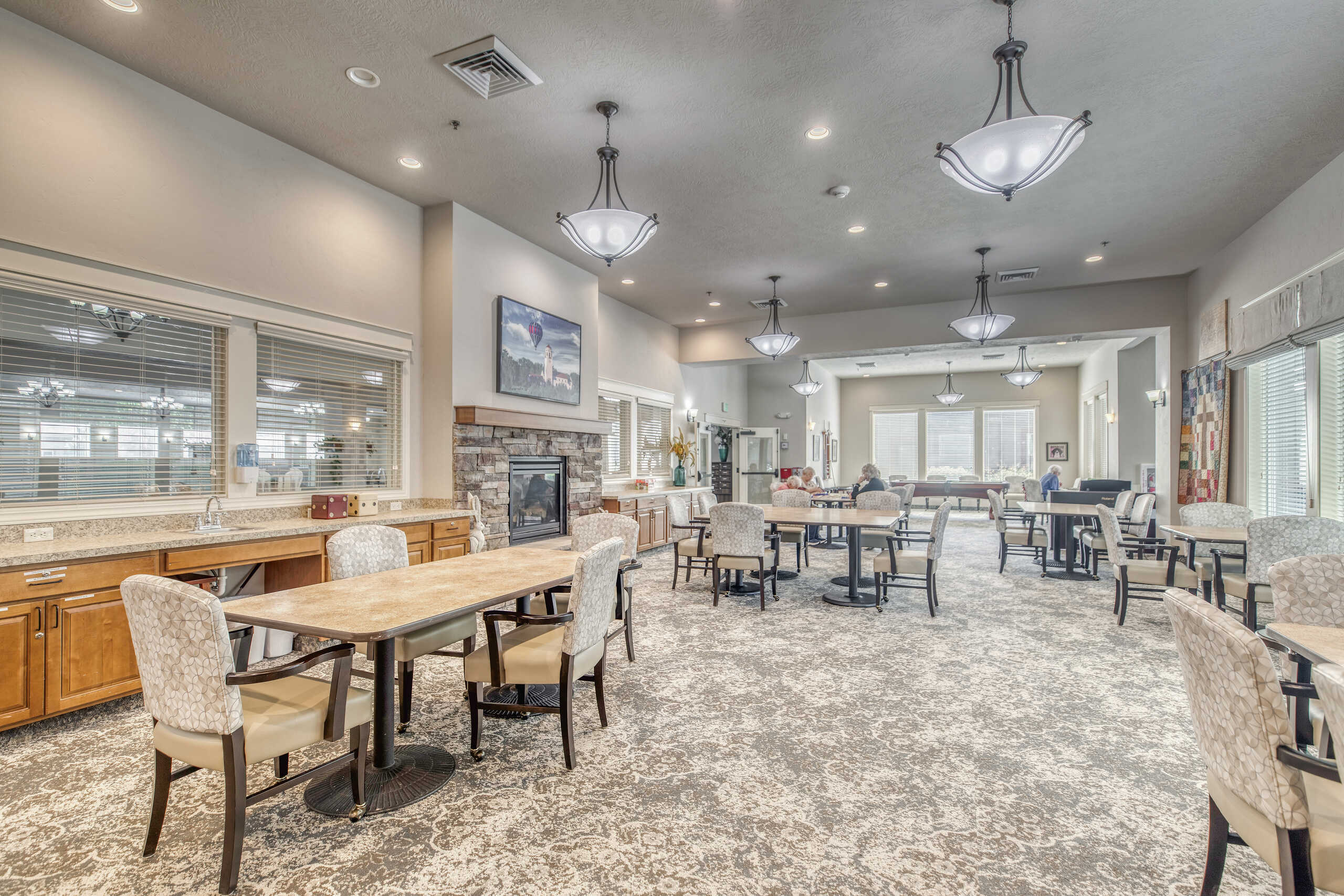Bright common area with residents and dining tables
