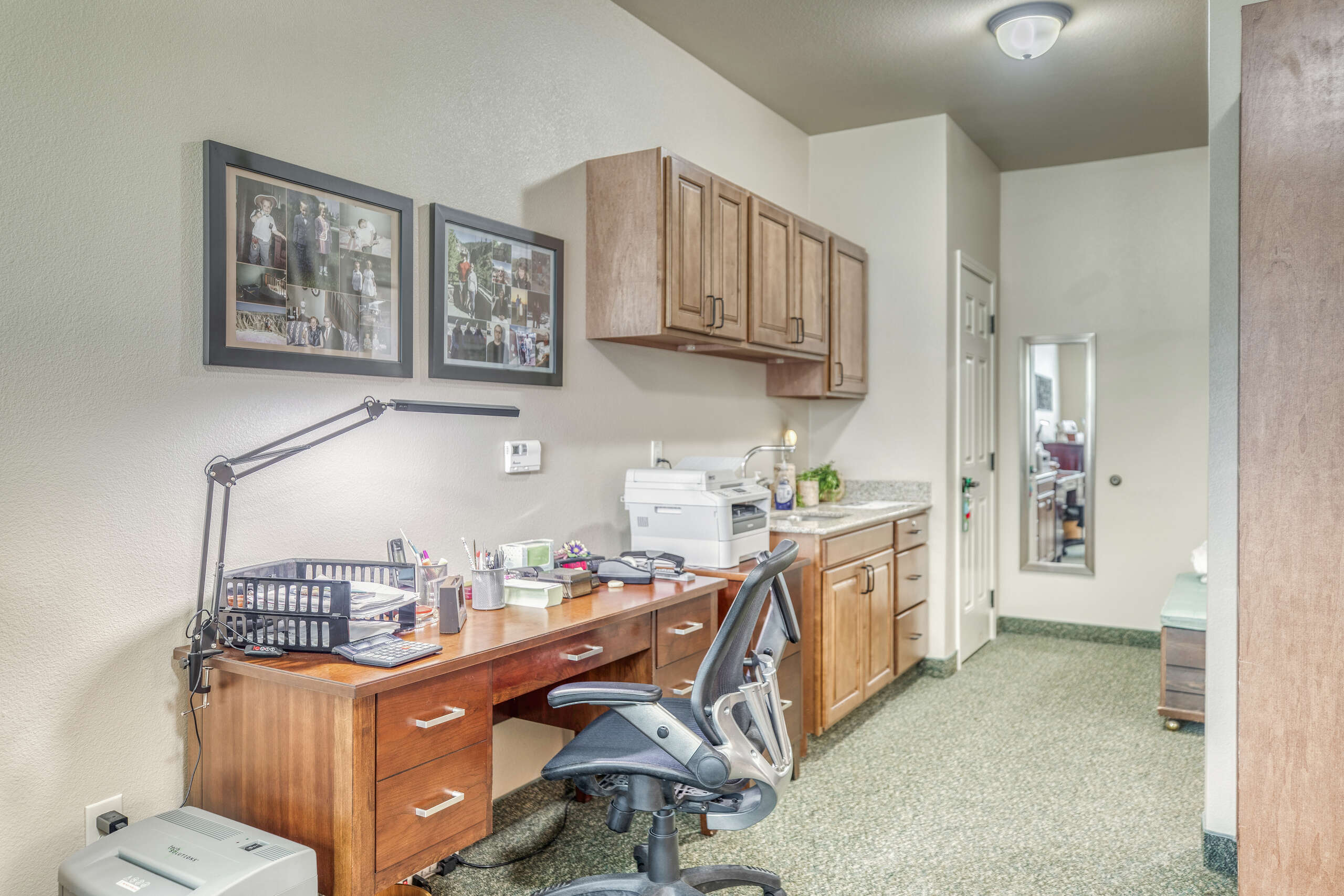 Well-furnished interior with a desk and photos on the wall