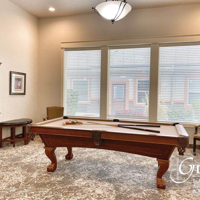 Interior game room with a pool table and sunlight