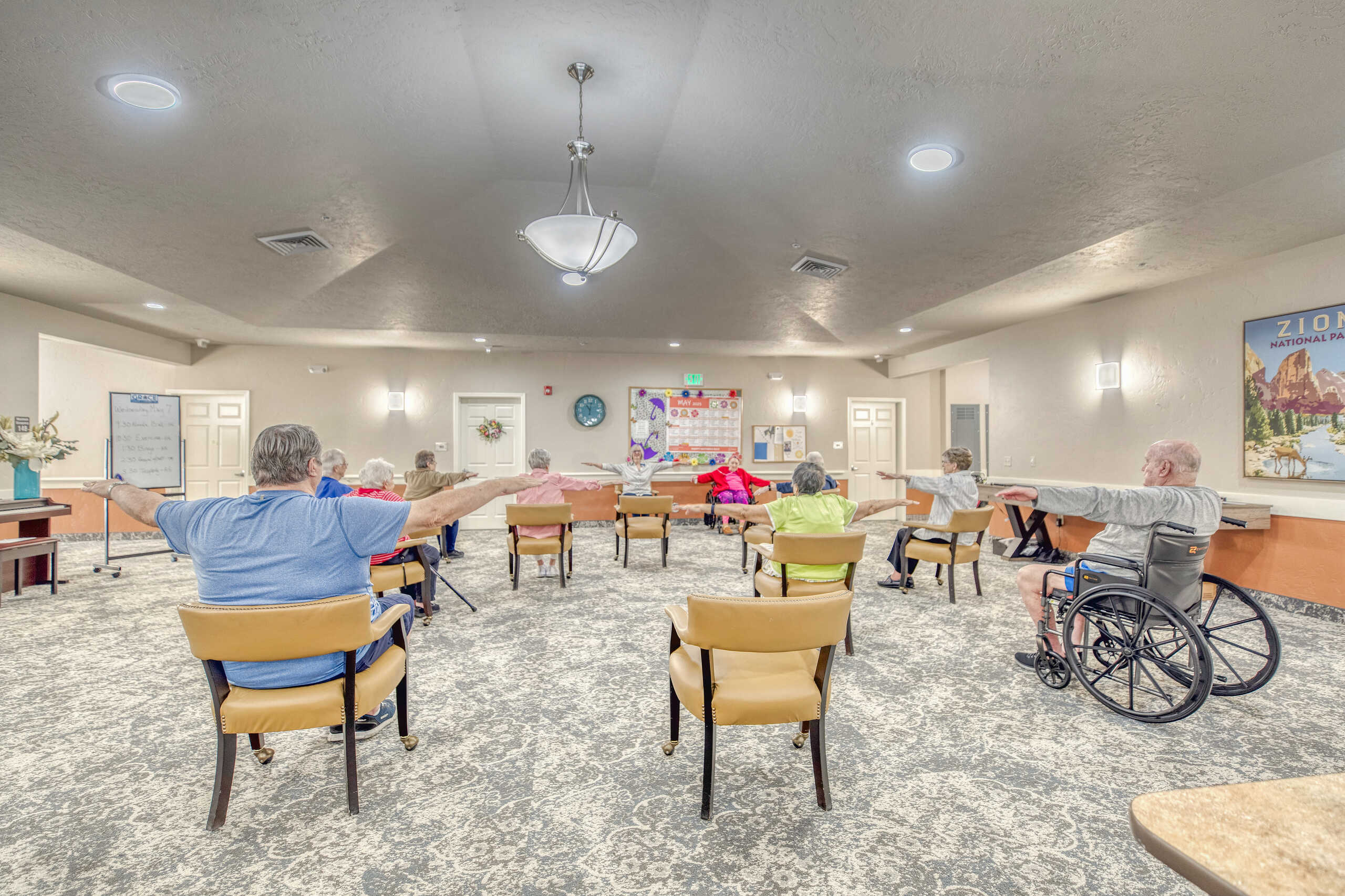 Residents participating in a seated exercise class in the activity room