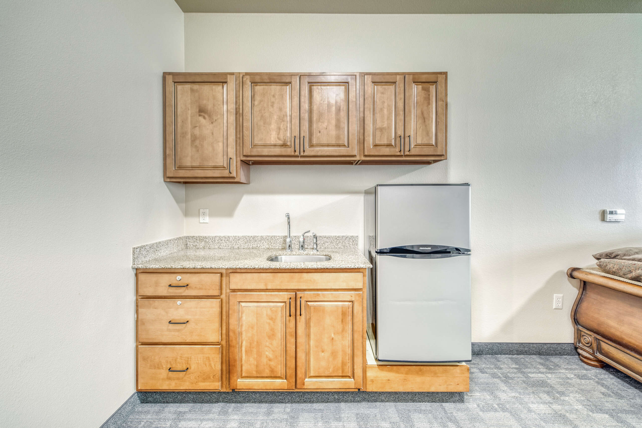 Kitchen area with cabinets and refrigerator
