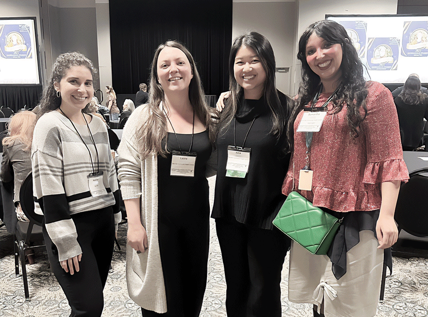 Group of four women smiling at an event.