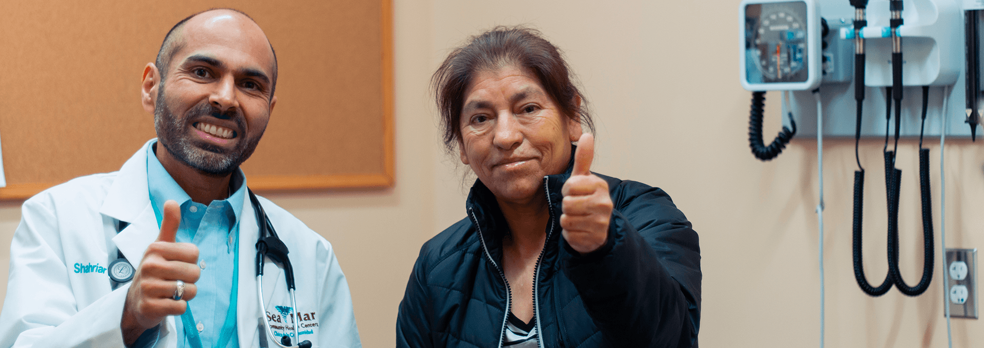 Doctor and patient giving thumbs up in an examination room.