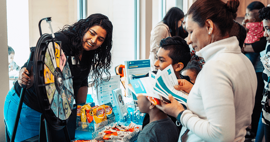 Engaged staff and children at an activity booth.