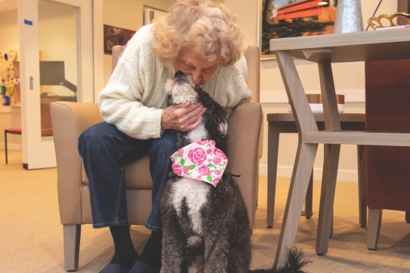 Senior woman interacting lovingly with a dog.