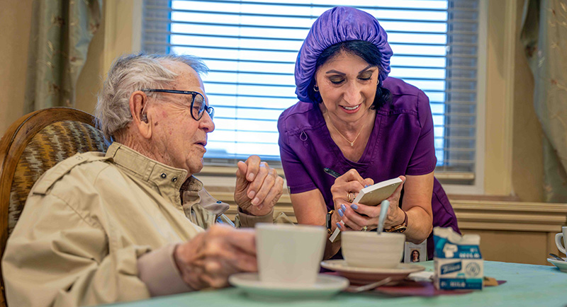 Staff assisting a resident during mealtime.