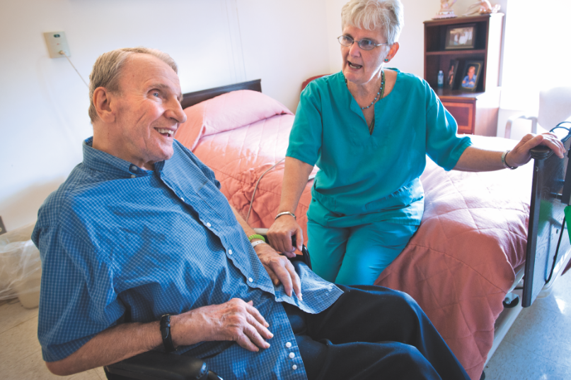 Resident and nurse interacting in a room