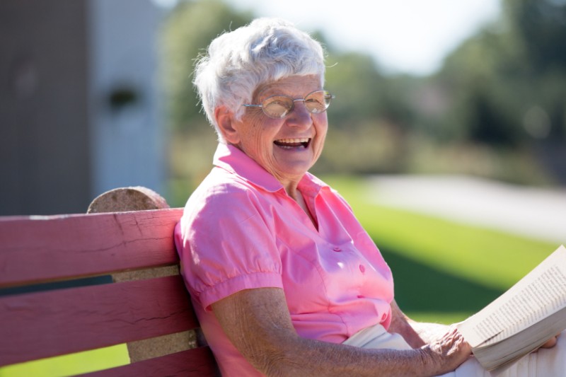 Senior woman reading and enjoying the outdoors.