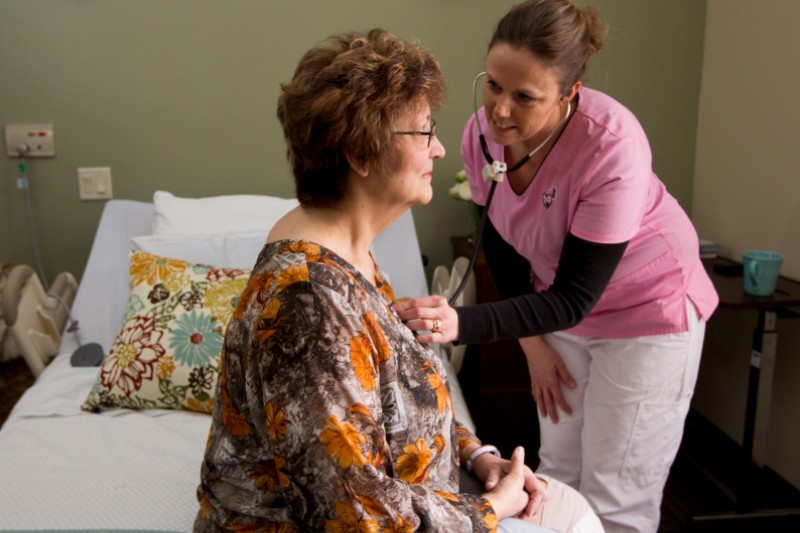 Nurse attending to a resident in a room