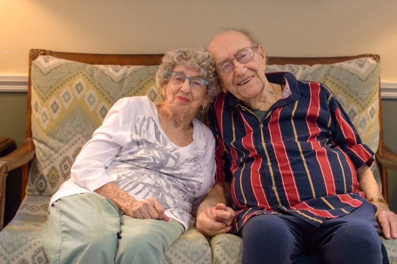 Two joyful residents sitting together on a couch.
