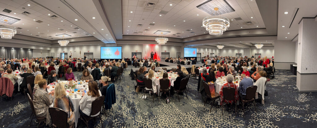 Large dining event with people seated at tables.