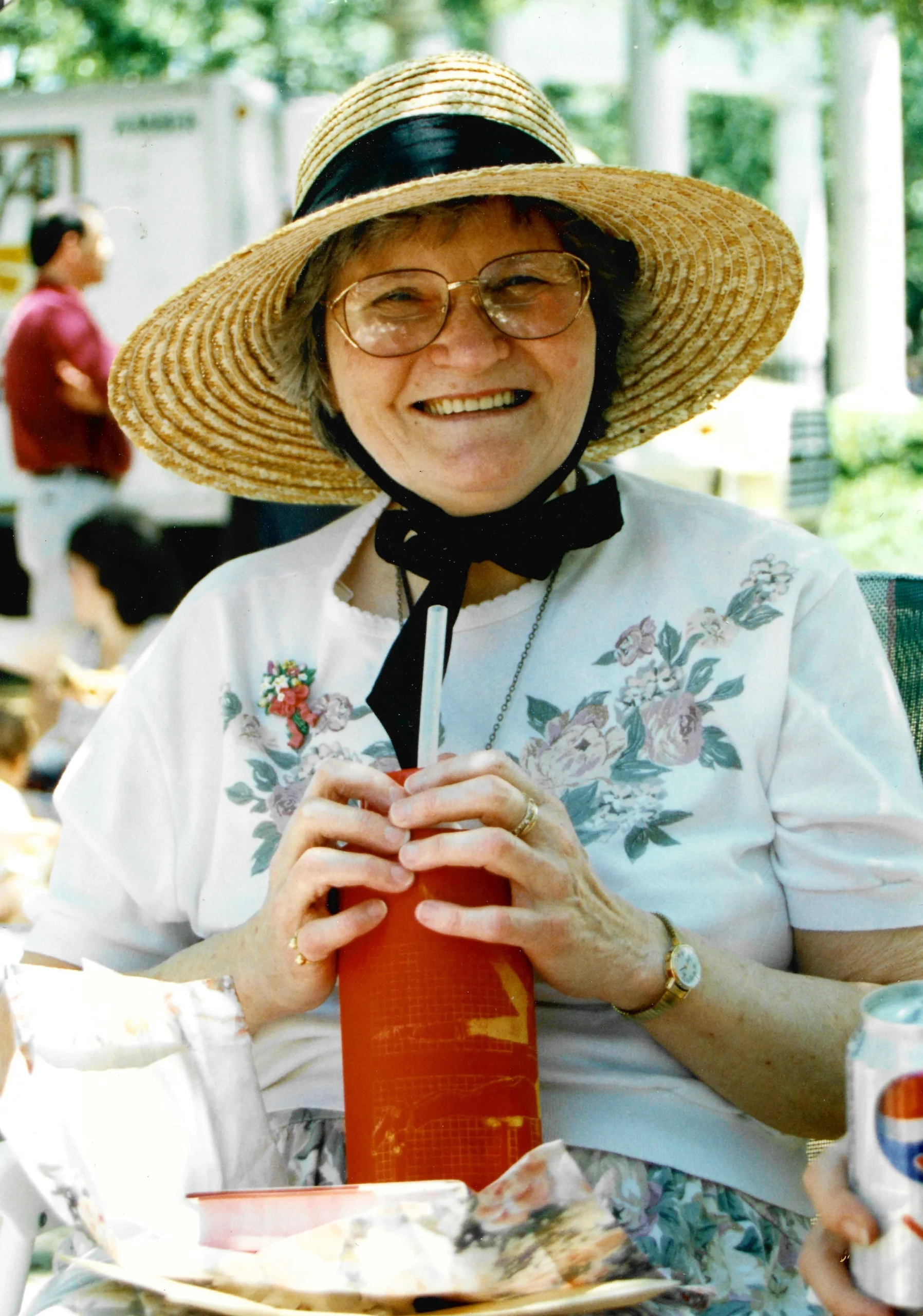 Senior woman enjoying a drink outdoors with food.