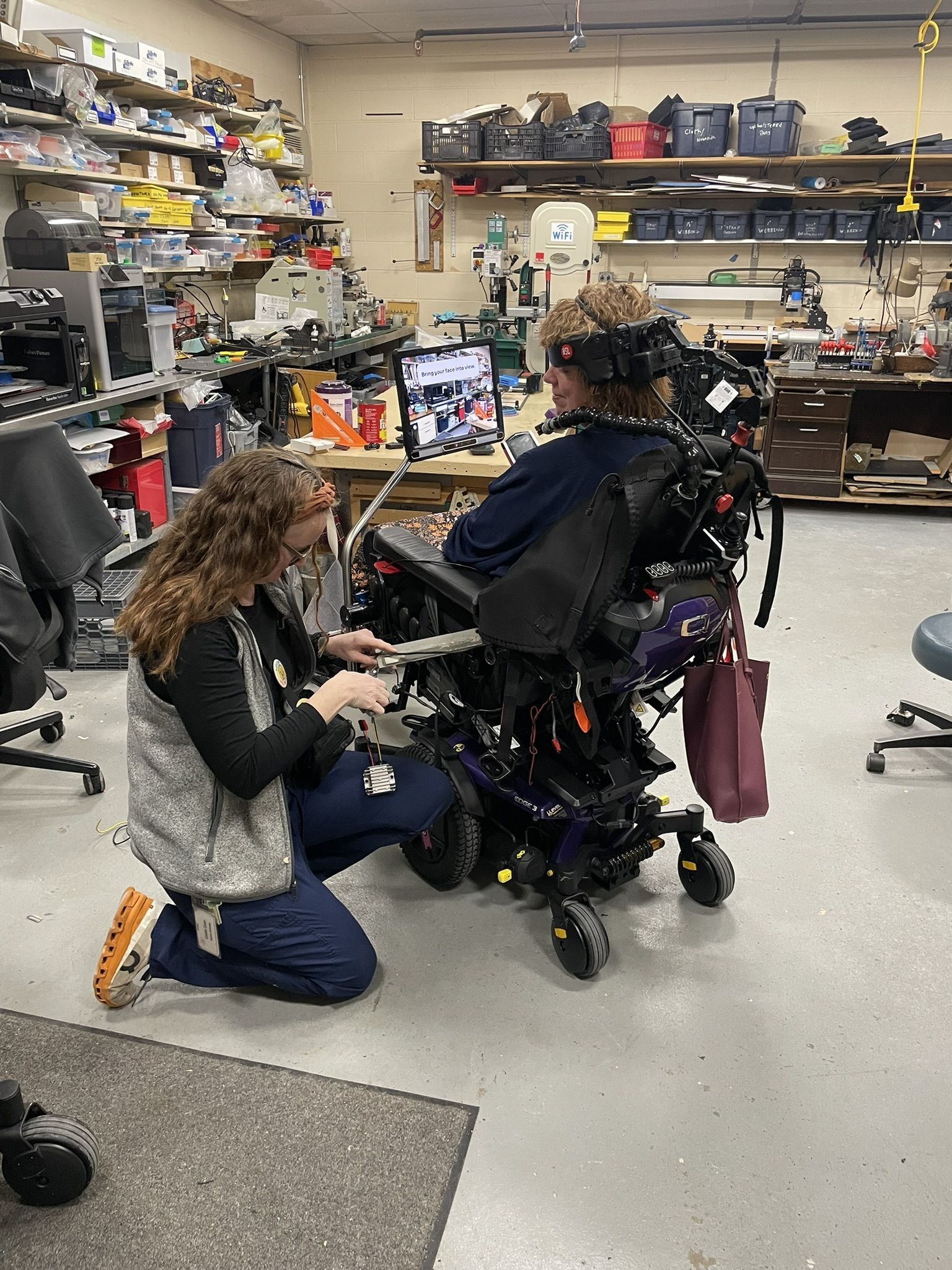An occupational therapist assisting a resident in a wheelchair.